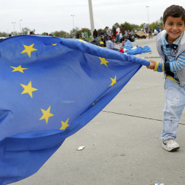 Un niño inmigrante juega con una bandera de la Unión Europea después de cruzar la frontera con Austria en Nickelsdorf, 5 de septiembre de 2015. REUTERS / Laszlo Balogh