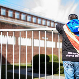 Un hombre con una estelada atada al cuello observa el interior de la prisión de Neumünster, donde está Puigdemont. | CLEMENS BILAN (EFE)