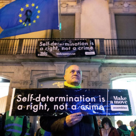 Una bandera europea con un crespón negro y una pancarta en inglés con el lema "La autodeterminación es un derecho, no un crimen", que los activistas de la ANC han colocado en el balcón de la sede de la Comisión Europea en Barcelona. EFE/ En