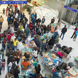 Grupos de voluntarios reparten comida, agua y ropa a los refugiados llegados a la estación de tren de Salzburgo, en Austria. EFE