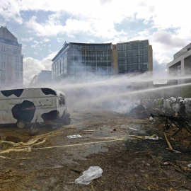 Ganaderos protestando contra la crisis del sector lácteo en Bruselas, mientras la Policía usaba cañones de agua para disuadirles. REUTERS