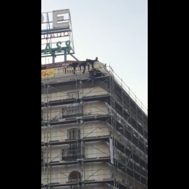 Fotograma de suceso cuando los bomberos forcejean con el presunto suicida para evitar que se tire.