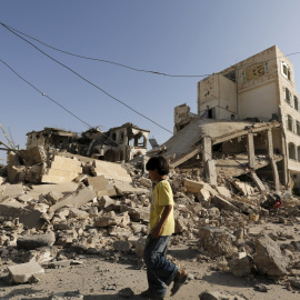 Un niño pasa junto a la casa del Brigadier Khaled al-Anduli, un comandante del ejército leal al movimiento Houthi, después de que fue golpeado por los ataques aéreos liderados por Arabia en la capital de Yemen, Saná. REUTERS