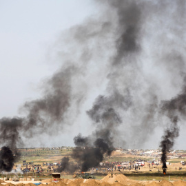 Palestinos queman neumáticos para dificultar la visibilidad de las tropas israelíes apostadas al otro lado. EFE