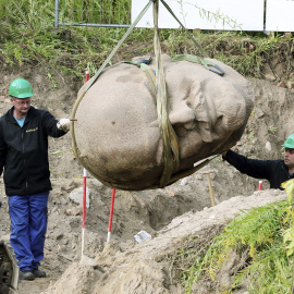 Trabajadores trasladan la cabeza de una escultura de Lenin en un bosque en Berlín (Alemania) hoy, 10 de septiembre de 2015. La cabeza del monumento de Lenin, que fue retirado en 1991, formará parte de la exposición "Revelado. Berlín y sus M