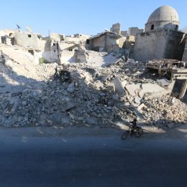 Un niño monta en bicicleta cerca de los escombros de los edificios dañados en el distrito de Al Maadi de Alepo, (Siria).- Abdalrhman Ismail (REUTERS)