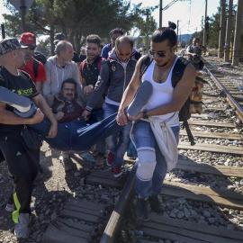 Un grupo de refugiados atraviesan la frontera entre Grecia y Macedonia, auxiliando a otro migrante. La mayoría proceden de Siria y atraviesan el autodenominado 'corredor de los Balcanes'. EFE/EPA/GEORGI LICOVSKI