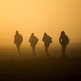 Refugiados caminan por el campo para evitar los controles de la policía en las vías del tren que conectan Horgos Szeged. cerca de Roszke en Hungría. EFE