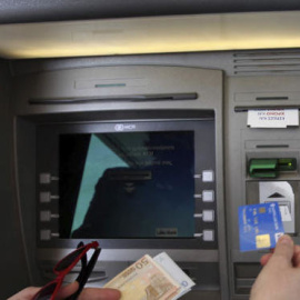 Un cliente saca dinero de un cajero automático. / EFE