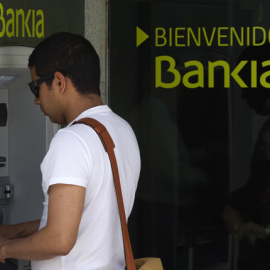 Un hombre retira dinero en un cajero de Bankia. EFE