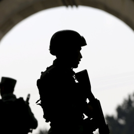 Las fuerzas de seguridad afganas hacen guardia cerca de la puerta principal del distrito Paghman, después de un ataque suicida, al norte de Kabul. REUTERS