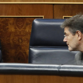 El ministro de Hacienda, Cristóbal Montero, conversa con el ministro de Justicia, Rafael Catalá, durante el Pleno del Congreso de los Diputados. EFE/ Fernando Alvarado