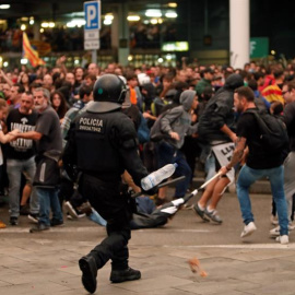 Un mosso d'esquadra durante una de las cargas contra las miles de personas que se agolparon en el aeropuerto del Prat. - EFE