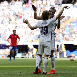 El jugador del Real Madrid, el croata Luka Modric (de espaldas), festeja el gol marcado al Osasuna con su compañero el galés Gareth Bale durante el partido de la tercera jornada de Liga que se ha disputado en el estadio Santiago Bernabéu. E