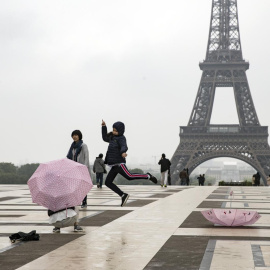 Dos turistas nipones se toman fotos delante de la torre Eiffel en Trocadero, París (Francia). EFE/Archivo