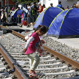 Refugiados descansan en tiendas de campaña instaladas en la estación de Tovarnik, Croacia. EFE/Antonio Bat