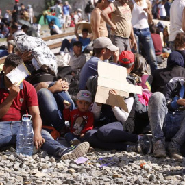 Refugiados esperan para ser registrados tras haber cruzado la frontera entre Serbia y Croacia en la estación de Tovarnik. / EFE
