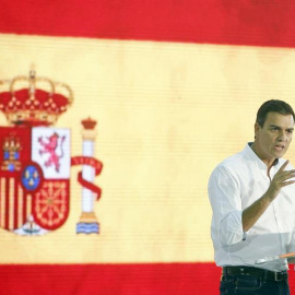 Pedro Sánchez con la bandera rojigualda durante el acto. EFE/Andreu Dalmau
