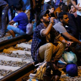 Un grupo de refugiados espera en la estación de la ciudad fronteriz de Tobarnik. / ANTONIO BRONIC (REUTERS)