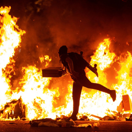 15/10/2019.- Un manifestante echa al fuego un cartón junto a la Delegación del Gobierno en Barcelona durante los incidentes producidos al finalizar la movilización convocada por los CDR, hoy martes en la segunda jornada de protestas contra 