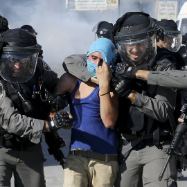 Un policía israelí detienen a un manifestante palestino durante los enfrentamientos que se produjeron en el campamento de refugiados de Shuafat, cerca de Jerusalén./ REUTERS/ Ammar Awad