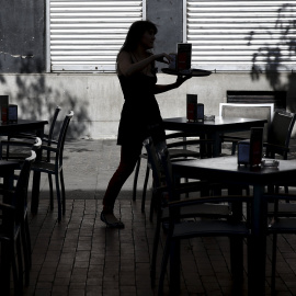 Una mujer atiende una terraza en el centro de Madrid. REUTERS