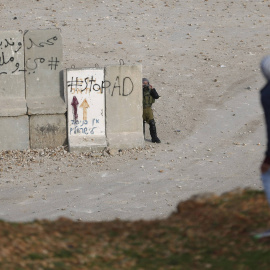 Un soldado israelí graba a un joven palestino. REUTERS