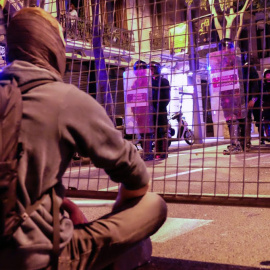 Manifestantes de los CDR, sentados pacíficamente con velas encendidas ante las vallas que después derribarían los infiltrados, provocando incidentes y cargas policiales. SERGI CAMARA