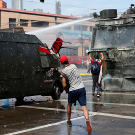 Manifestantes lanzan sillas a las furgonetas policiales en Santiago de Chile. /REUTERS