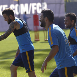 Arda Turan junto a los compañeros del FC Barcelona Alex Vidal y Dani Alves, durante el entrenamiento de la plantilla en la Ciudad Deportiva Joan Gamper. EFE/Alejandro García