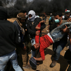 Varios palestinos trasladan a un herido. - REUTERS