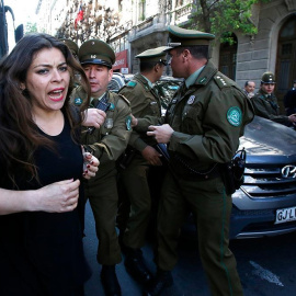 Imagen de la detención de una mujer en las protestas de Chile