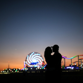Una pareja se besa enfrente del muelle de Santa Mónica.  REUTERS/Lucy Nicholson