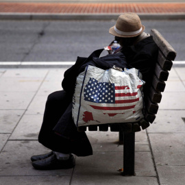 Una mujer sin hogar descansa en un banco a pocos metros de la Casa Blanca en Washington. CARLOS BARRIA (AFP)