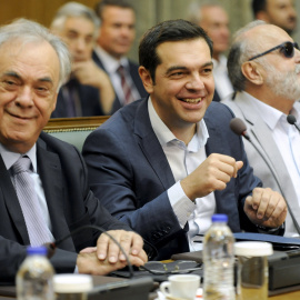 El primer ministro griego, Alexis Tsipras, entre el viceprimer ministro, Yannis Dragasakis (i), y el ministro de Interior, Panagiotis Kourouplis, en la primera reunión de su gabinete tras las elecciones del pasado día 20 de septiembre. REUT