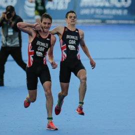 Alistair Brownlee (i) de Gran Bretaña ayuda a su hermano Jonathan Brownlee (d) a terminar la carrera en Cozumel (México). /EFE