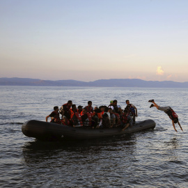 Refugiado sirio se tira al mar cuando su embarcación se acerca a una playa de la isla griega de Lesbos, después de cruzar el Mar Egeo. REUTERS