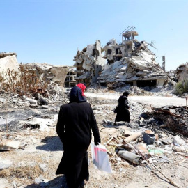 Mujeres sirias caminan entre las ruinas de la ciudad Homs, Siria. EFE/Youssef Badawi
