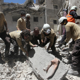 Miembros de los servicios de rescate civiles buscan supervivientes tras un un reciente bombardeo en Ariha, en la provincia siria de Idlib. - REUTERS