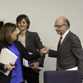 El ministro de Hacienda, Cristóbal Montoro, la vicepresidenta del Gobierno, Soraya Sáenz de Santamaría (i), y la ministra de Agricultura, Alimentación y Medio Ambiente, Isabel García Tejerina (c), al inicio de la rueda de prensa que han ofr