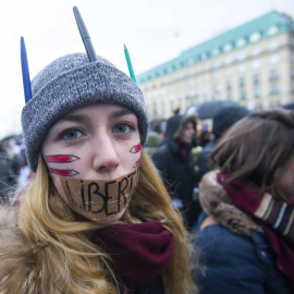 A woman wears a tape with the word 'Liberte' (Freedom) on her mouth during a silent protest for the victims of the shooting at the Paris offices of weekly newspaper Charlie Hebdo, at the Pariser Platz square in Berlin January 11, 2015. REUT