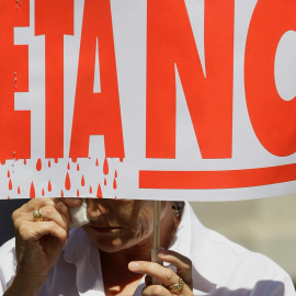Un hombre solloza mientras sostiene una pancarta contra ETA en un minuto de silencio frente al Ayuntamiento de Madrid, tras un atentado de la organizacion terrorista en Mallorca en el que mató a dos guardias civiles, en julio de 2009. REUTE