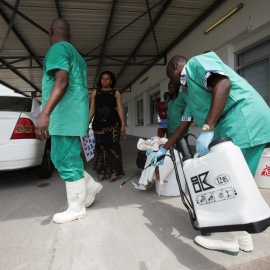 Un trabajador de sanidad rocía a un compañero con desinfectante durante una sesión de capacitación para tratar el virus del ébola en el Congo. REUTERS/Media Coulibaly/Archivo  Foto del 21 de octubre de 2014