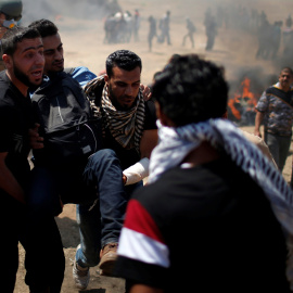 Varios palestinos trasladan a un herido en las protestas en Gaza contra la embajada de EEUU en Jerusalén. - REUTERS