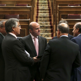 El ministro de Economía, Luis de Guindos, el pasado miércoles, rodeado de diputados del PP en el hemiciclo del Congreso de los Diputados. EFE