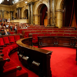 El Parlament lucía con sus primeros asientos vacíos tras la marcha del grupo de Cs antes de la votación. / EFE