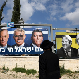 27/03/2019 - Un judío ortodoxo observa los carteles de la campaña electoral israelí. / REUTERS - AMMAR AWAD