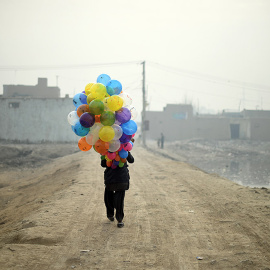 Un vendedor de globos afgano de 19 años busca clientes en un barrio de Kabul. /SHAH MARAI (AFP)