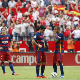 El centrocampista croata Ivan Rakitic, el delantero uruguayo Luis Suárez y el delantero brasileñoNeymar, del FC Barcelona, tras encajar el segundo gol del Sevilla. / PACO PUENTES (EFE)