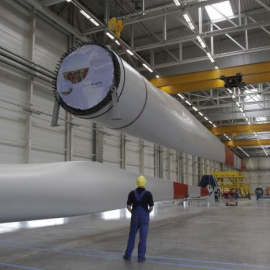 Un trabajador mira un ala que está siendo levantada mecánicamente en la fábrica de turbinas eólicas de Nordex en Rostock. REUTERS / Tobias Schwarz